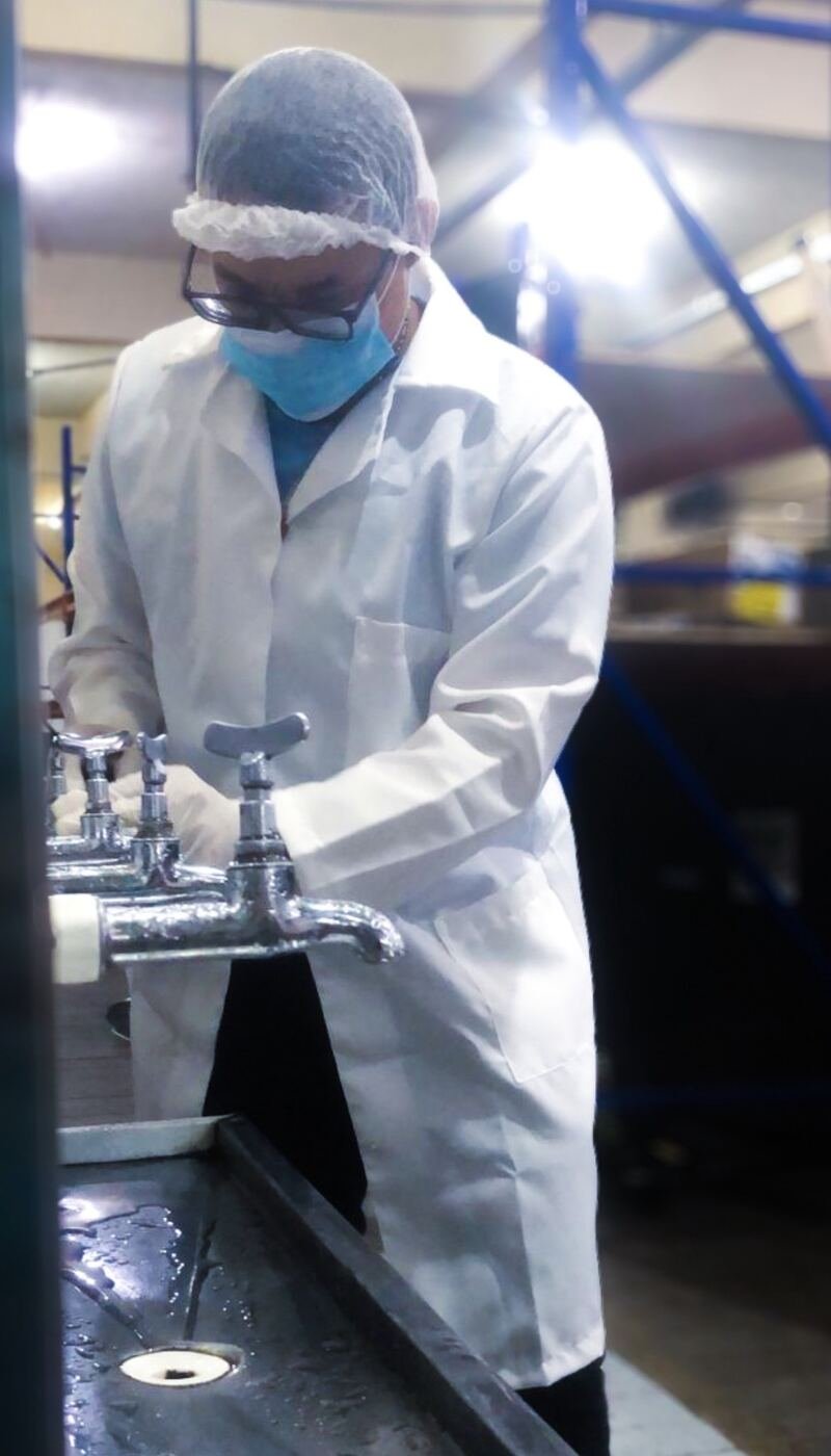 Técnico coletando água de torneiras em indústria